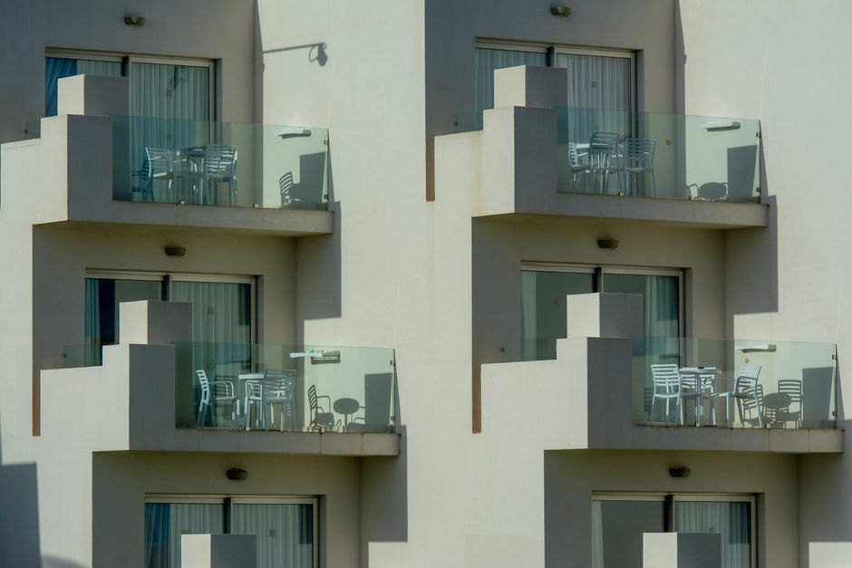 Architectural view of modern apartment balconies with sleek glass railings and outdoor furniture